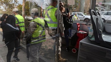 Soldados chequean los permisos de circulación de transeúntes en Santiago (AP Photo/Esteban Felix)