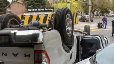 El vehículo accidentado en primer plano, y al fondo la magistrada en el cordón de la vereda.