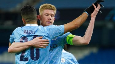 Kevin De Bruyne (derecha) del Manchester City celebra con Riyad Mahrez tras anotar el primer gol del equipo en el partido contra Borussia Dortmund por la Liga de Campeones, el martes 6 de abril de 2021, en Manchester. (AP Foto/Dave Thompson)