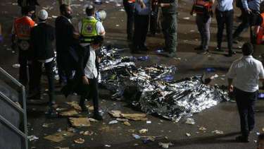 La policía y rescatistas recuperan cuerpos después de la estampida