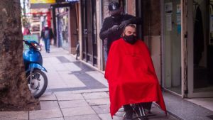 Un peluquero de Mar del Plata atiende a sus clientes en la vereda, por las restricciones