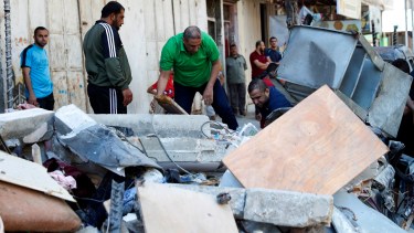 Palestinos revisan el edificio de Abu Hussein, en Gaza después de un ataque israelí (AP /Adel Hana)