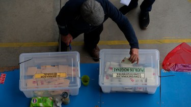 Un elector deposita su voto en la urna con el cupo para pueblos indígenas (AP Photo/Esteban Felix)