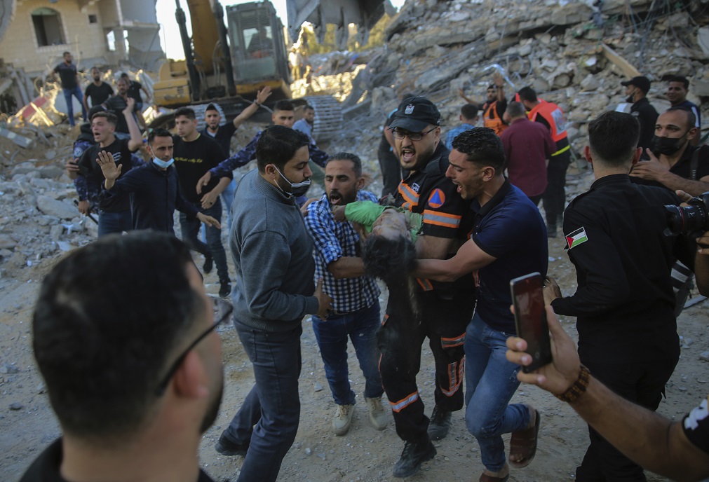 Rescatistas sacan el cuerpo de un niño palestino de los restos de un edificio destruido por bombardeos israelíes en Beit Lahiya, norte de la Franja de Gaza (AP/Abdel Kareem Hana)