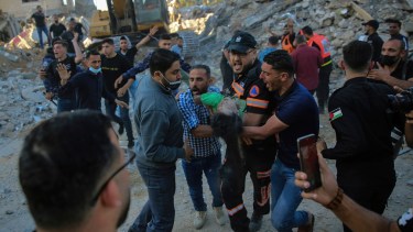 Rescatistas sacan el cuerpo de un niño palestino de los restos de un edificio destruido por bombardeos israelíes en Beit Lahiya, norte de la Franja de Gaza (AP/Abdel Kareem Hana)