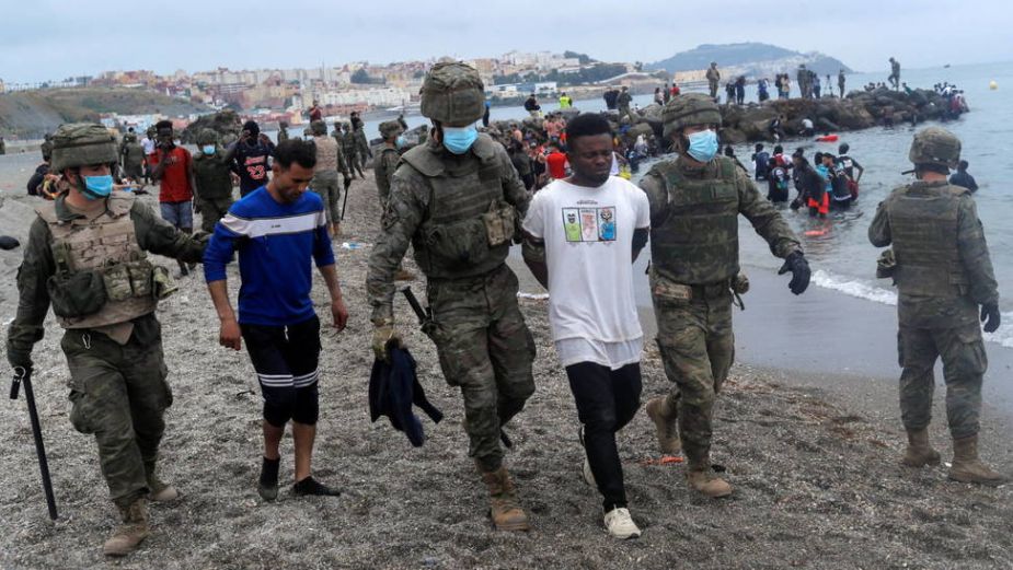 Miembros del Ejército de Tierra detienen a migrantes que han logrado cruzar la frontera de Ceuta. Foto: Reuters.-