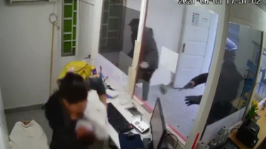 Con su hijo en brazos, la mujer logró escapar de la violenta acción de los delincuentes. (foto: video original)