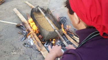 El trigo se coloca en la cayana para ser tostado a fuego muy lento, mientras de lo mueve constantemente.