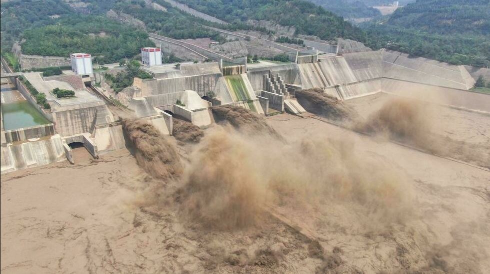 Esta foto aérea tomada el 5 de julio de 2021 muestra el agua que se libera de la presa del embalse Xiaolangdi en Luoyang, en la provincia central china de Henan, que ha sido golpeada por tormentas severas y lluvias torrenciales (Foto AFP)
