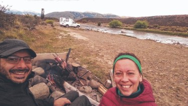 Pablo y Karen y un asadito en el río Centinela, cerca de El Calafate, Santa Cruz. Detrás, la ambulancia que transformaron en un camper para viajar y vivir a bordo. Los amigos la bautizaron "La Moscovita". 