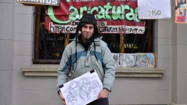 Cristian Valverde dibuja en la entrada del banco Nación desde 1997. Foto: archivo