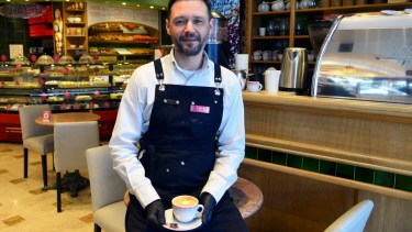 Yevgen Vyshnyakov (Eugenio) en la confitería donde crea el café a la altura de las exquisiteses que cocinan los reposteros, en el centro de Bariloche. Foto: Chino Leiva