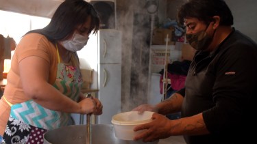 A las 12 se reparte la comida a los vecinos del barrio. Todos deben llevar un taper y también reciben tortas fritas. Foto Emiliana Cantera.