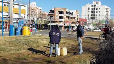 Con bidones, los vecinos le pedían agua a los placeros esta mañana. No es agua potable pero les sirvió para las tareas de higiene en el hogar. (foto: César Izza)