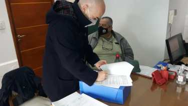 El secretario de la Legislatura, Alejandro Cortes firma la cesión de los lotes. Gatica recuperó la conducción de APEL y, ahora, el manejo de los lotes de la causa, que derivó en su condena penal. Foto: Gentileza. 