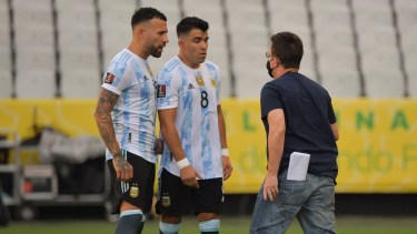 Nicolás Otamendi y el zapalino Marcos Acuña discuten con el brasileño que entró a la cancha a frenar el partido. Foto: Telam