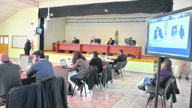 El tribunal en la sala de audiencias. La fiscalía y las querellas concurren al salón de AMUC. Las defensas están de forma virtual. Foto Yamil Regules.