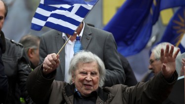 FILE - In this Sunday, Feb. 4, 2018 file photo, famous Greek composer Mikis Theodorakis waves a Greek flag after his speech at a rally in Athens, Greece. Mikis Theodorakis, the beloved Greek composer whose rousing music and life of political defiance won acclaim abroad and inspired millions at home, died on Thursday, Sept. 2, 2021. He was 96. (AP Photo/Petros Giannakouris, File)