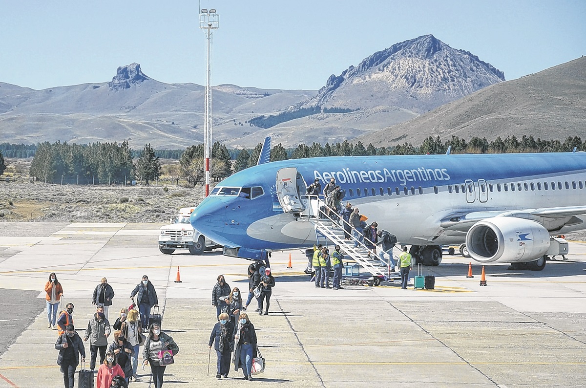 Los pasajeros caminan por la pista de aterrizaje. A futuro tendrán una manga para el ascenso y descenso. Foto: Patricio Rodríguez