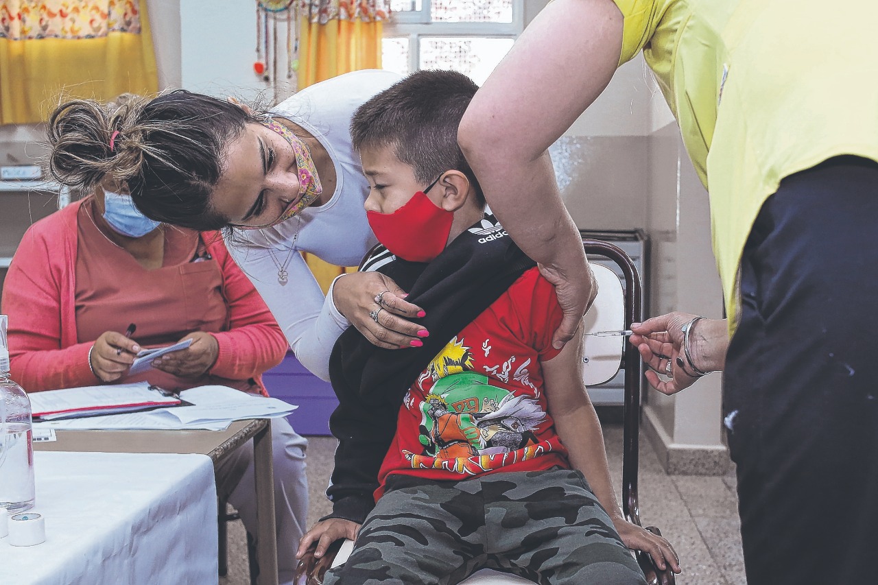 "Sí que duele má". Toda la contención posible se desplegó en las salitas de vacunación en las escuelas de Roca.  Foto Juan Thomes