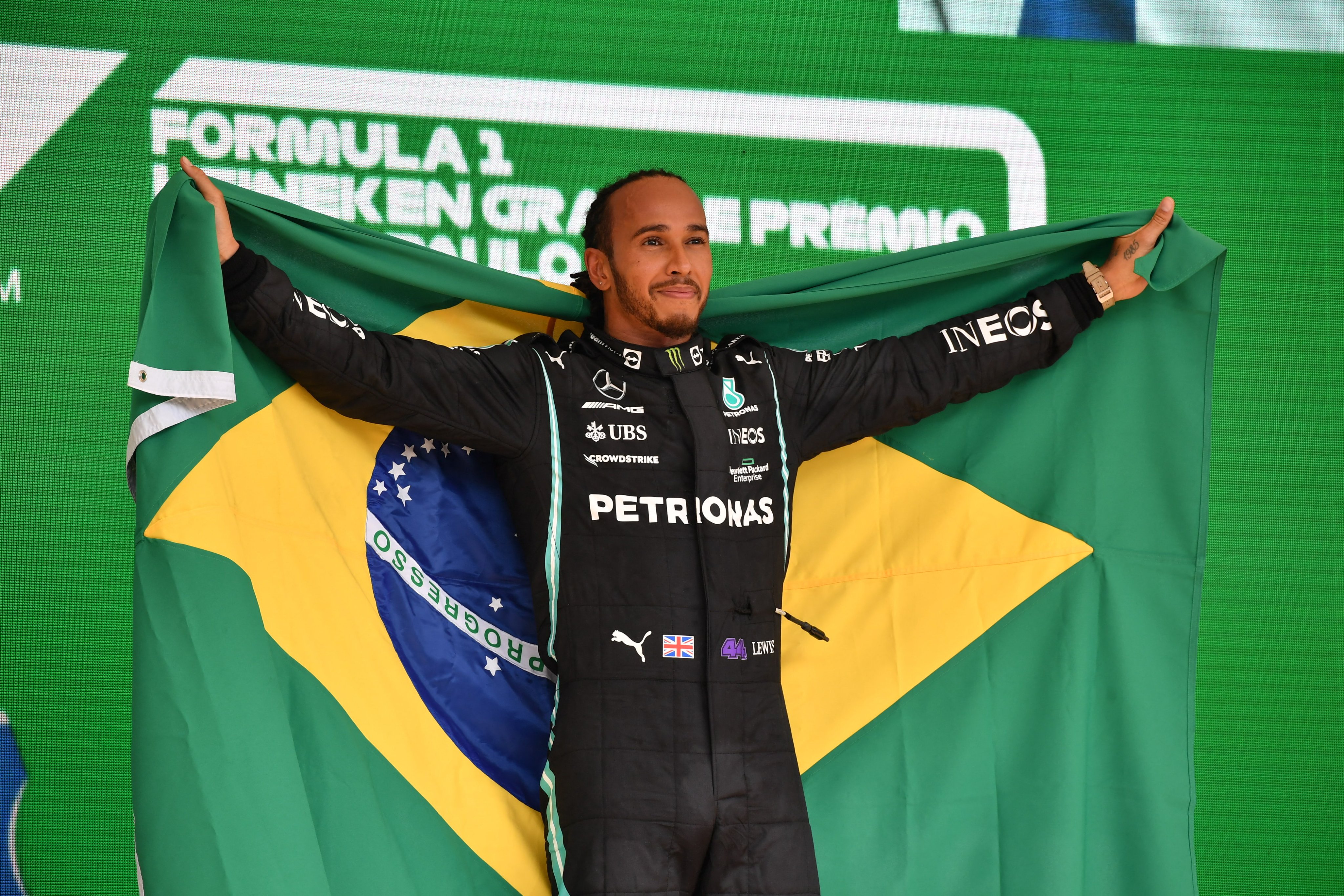 Lewis Hamilton con la bendera brasileña en Interlagos, festejando su gran victoria. 