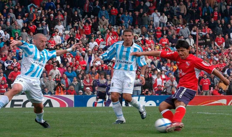 La definición de la jugada del Kun contra Racing. Agüero remata ante la marca de Diego Crosa y atrás mira Diego Simeone. 