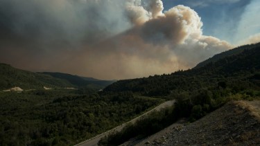 Las enormes columnas de humo del incendio forestal complican mucho la visibilidad para transitar en la ruta nacional 40, en el tramo del Cañadón de la Mosca. (foto Marcelo Martínez)