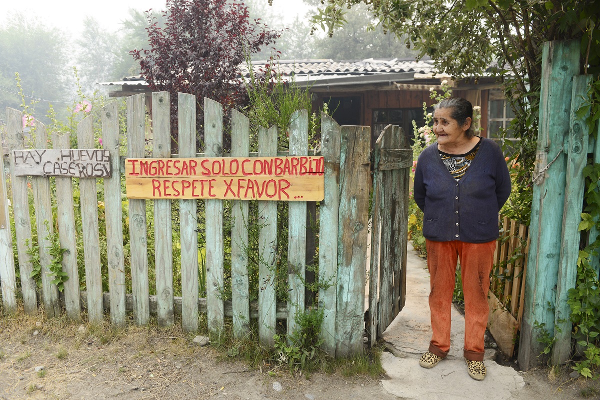 Andina Enriquez atiende su kiosco en Río Villegas, es una de las pobladoras históricas que hoy resiste al desalojo ante el avance del incendio. Foto: Chino Leiva