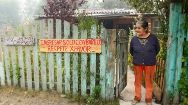 Andina Enriquez atiende su kiosco en Río Villegas, es una de las pobladoras históricas que hoy resiste al desalojo ante el avance del incendio. Foto: Chino Leiva