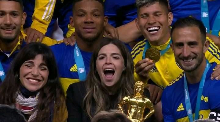 Dalma con el trofeo al lado de su hermana Giannina y de Carlos Izquierdoz, capitán de Boca. 