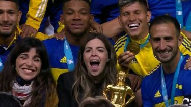 Dalma con el trofeo al lado de su hermana Giannina y de Carlos Izquierdoz, capitán de Boca. 
