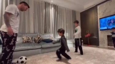 Messi se divierte con sus hijos, en el living de su casa parisina.-