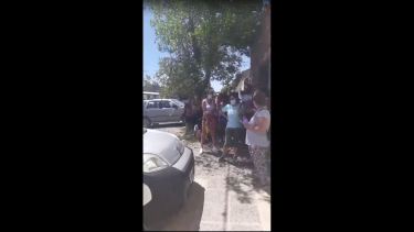 Las personas esperan su turno buscando algo de sobra para resguardarse del sol.  Foto: Captura de video