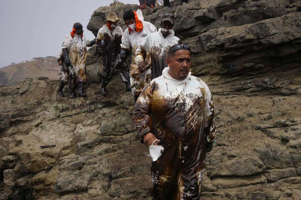 Trabajadores de limpieza finalizan su jornada llenos de petróleo. (AP Photo/Martin Mejia)