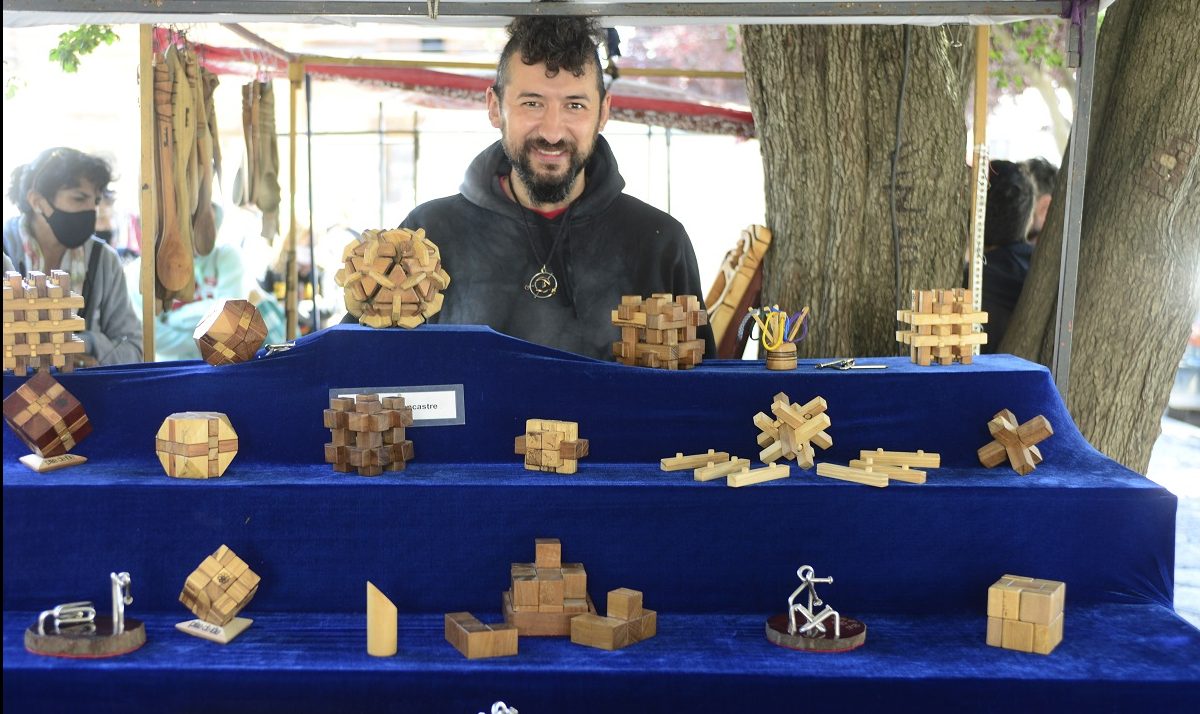 Nicolás Petersen está todos los días, con sus juegos de ingenio en madera,  en la feria de la calle Urquiza, en el Centro Cívico de Bariloche. Foto: Chino Leiva