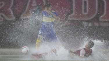 Un jugador de Boca intenta pasar a otro de Independiente detrás del agua. Un partido que quedará en la memoria. Foto: Télam