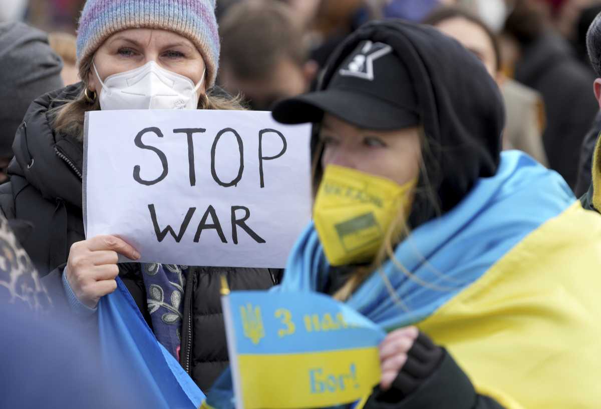 La gente asiste a una manifestación de protesta a favor de Ucrania frente a la Puerta de Brandenburgo en Berlín, Alemania, el jueves 24 de febrero de 2022 después de que las tropas rusas lanzaran su ataque anticipado contra Ucrania.  