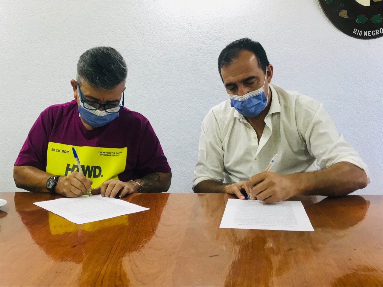 Ramiro Lagos y el intendente de Huergo, Miguel Martínez firmaron el contrato para dar cumplimiento a la ley de cupo laboral trans. (Foto Néstor Salas)