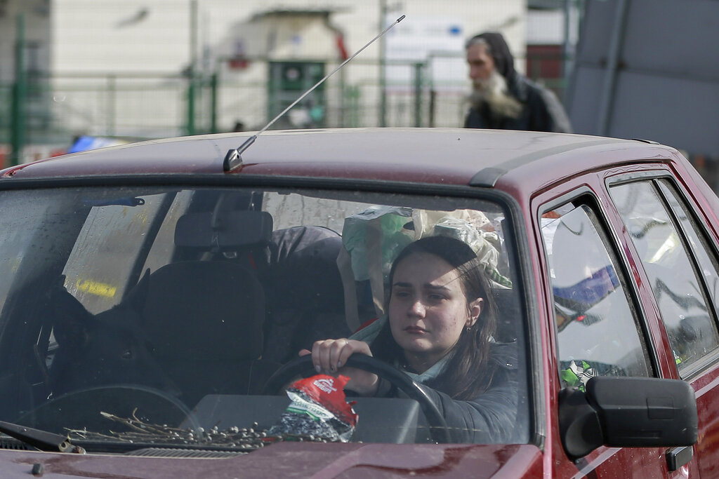 Una mujer cruza la frontera ucraniana a bordo de su auto.  (AP Photo/Visar Kryeziu)