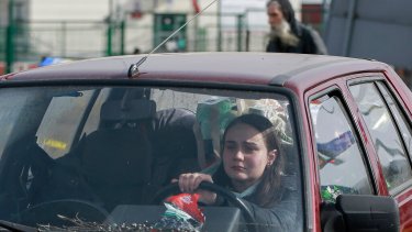 Una mujer cruza la frontera ucraniana a bordo de su auto.  (AP Photo/Visar Kryeziu)