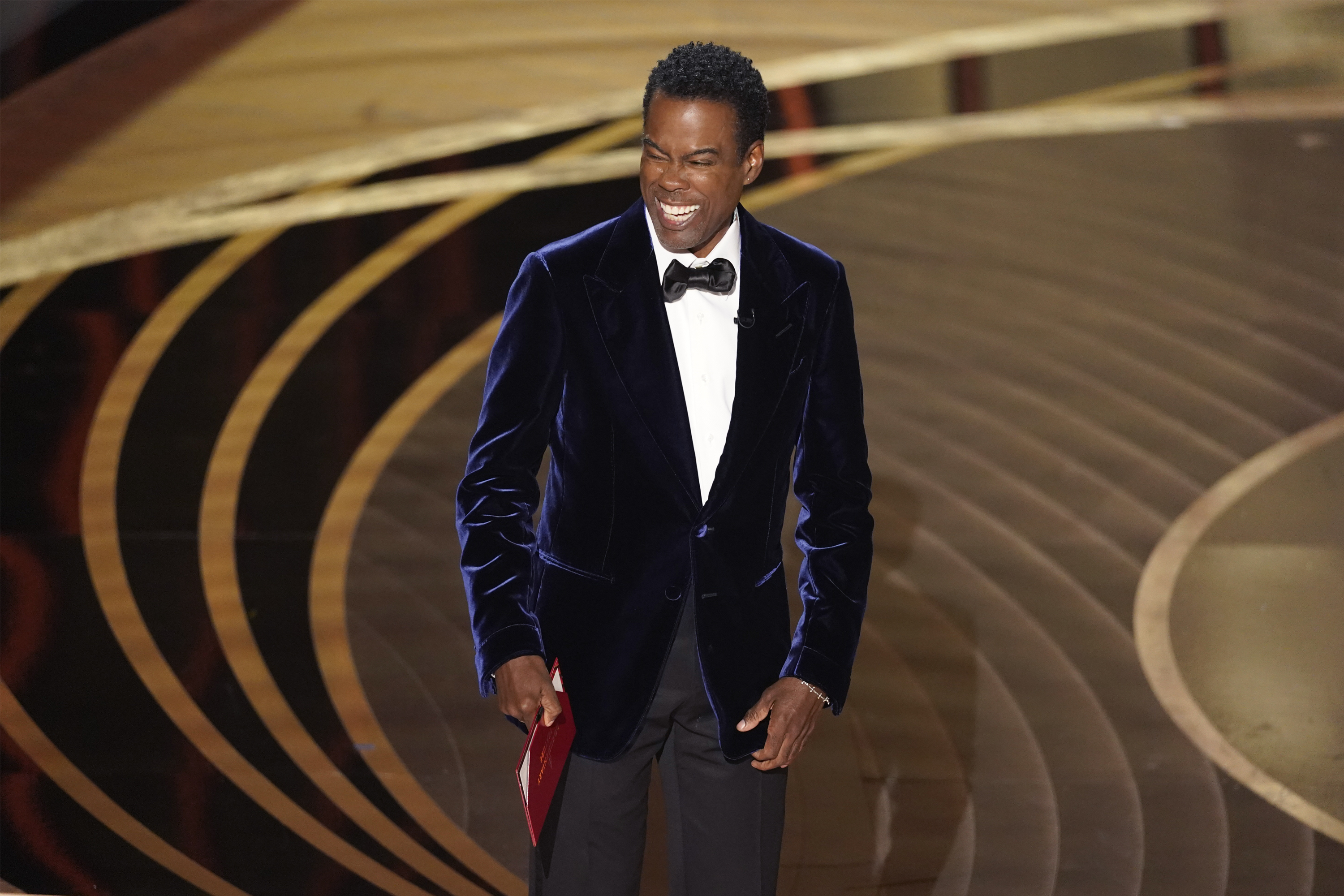 Chris Rock presents the award for best documentary feature at the Oscars on Sunday, March 27, 2022, at the Dolby Theatre in Los Angeles. (AP Photo/Chris Pizzello)