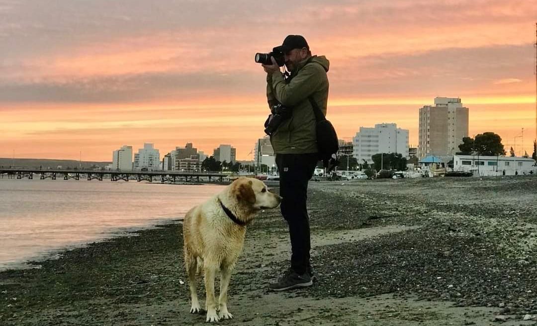 Luis Pereyra en acción. De cara al mar de Puerto Madryn, como le gusta. Y con el labrador Aslan, que siempre lo acompaña a nadar y cuando sale a sacar fotos. 