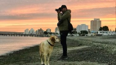 Luis Pereyra en acción. De cara al mar de Puerto Madryn, como le gusta. Y con el labrador Aslan, que siempre lo acompaña a nadar y cuando sale a sacar fotos. 
