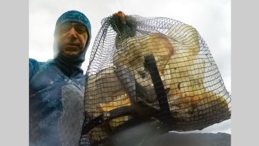 El médico recolecta la basura del lago mientras bucea. Foto: Facebook @anfitrionesvla