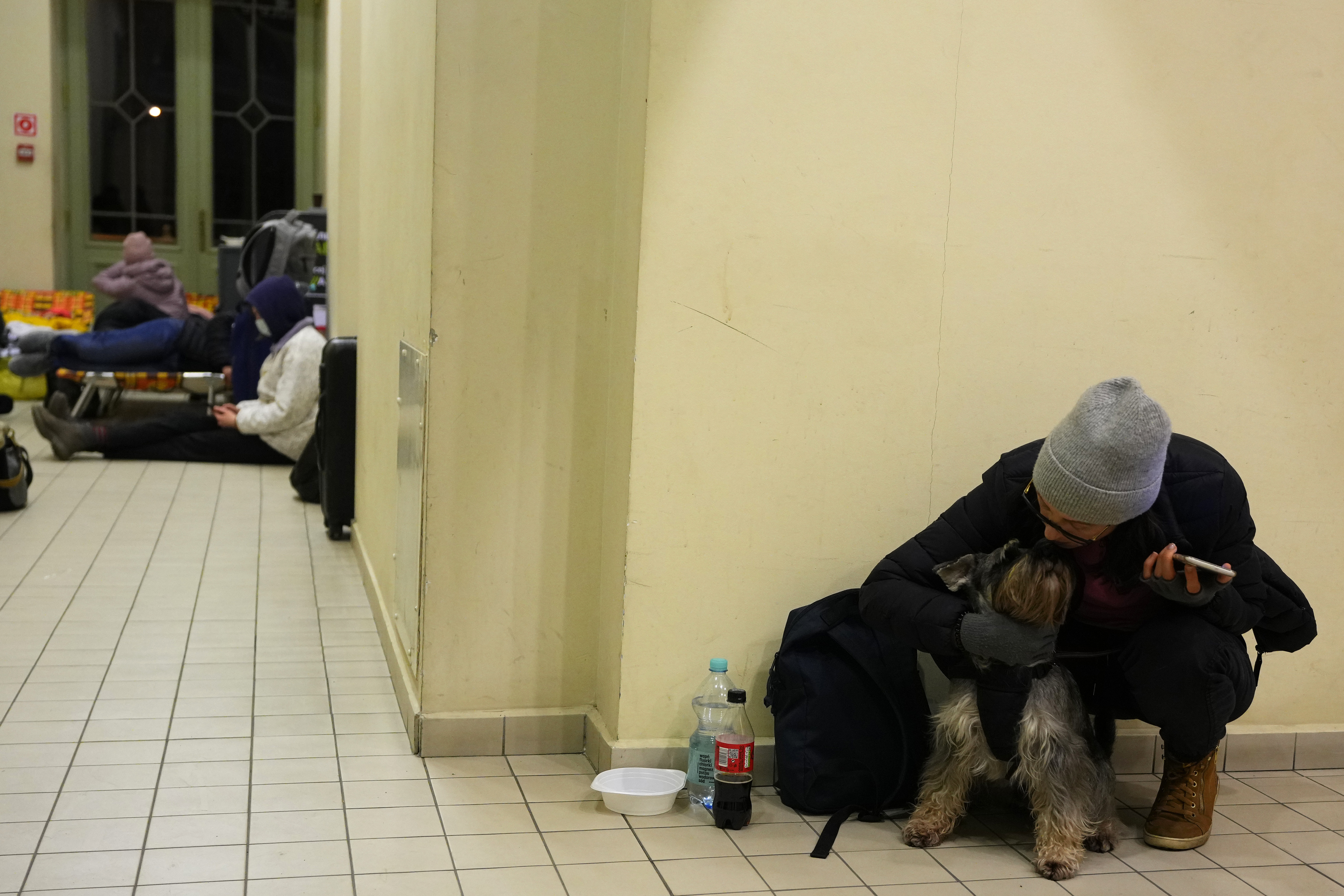 Una mujer ucraniana se sienta con su perro en una estación de tren que se convirtió en un centro de alojamiento en Przemysl, Polonia(AP Photo/Petr David Josek)