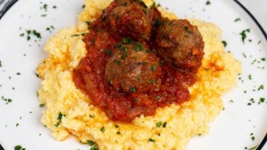 Alta polenta cremosa con albóndigas