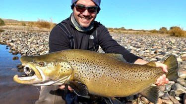 La alegría de Mauricio ante la trucha marrón de casi seis kilos que pescó y devolvió en el Limay Medio, al norte de la Patagonia.