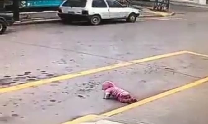 Las cámaras captaron como un vecino salvó a  una bebé que gateaba por la calle. Foto: Captura video