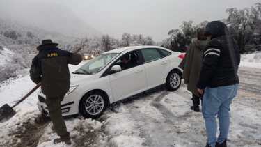 Personal de Parques Nacionales auxilia a un conductor, cuyo vehículo quedó atascado en la nieve por el temporal. (foto gentileza)