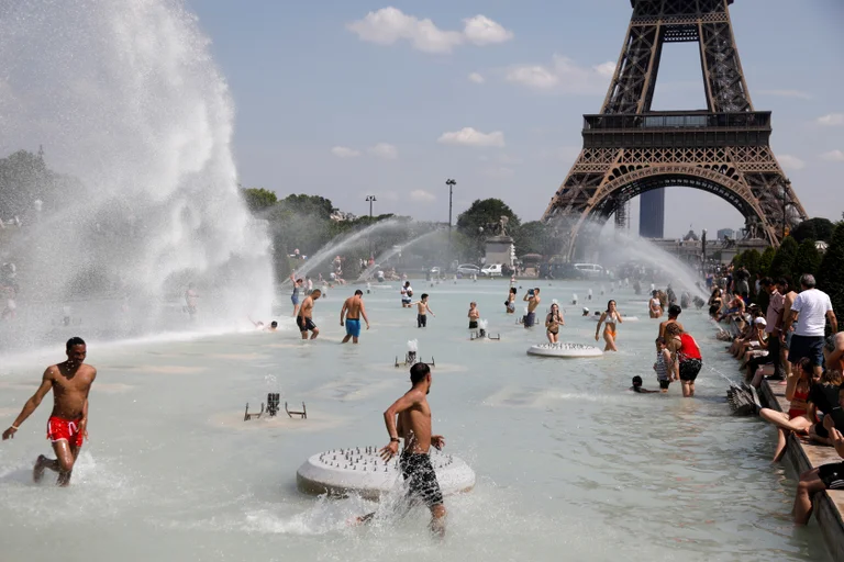En las piletas y fuentes de la Torre Eiffel, las personas buscan refrescarse (Reuters)
